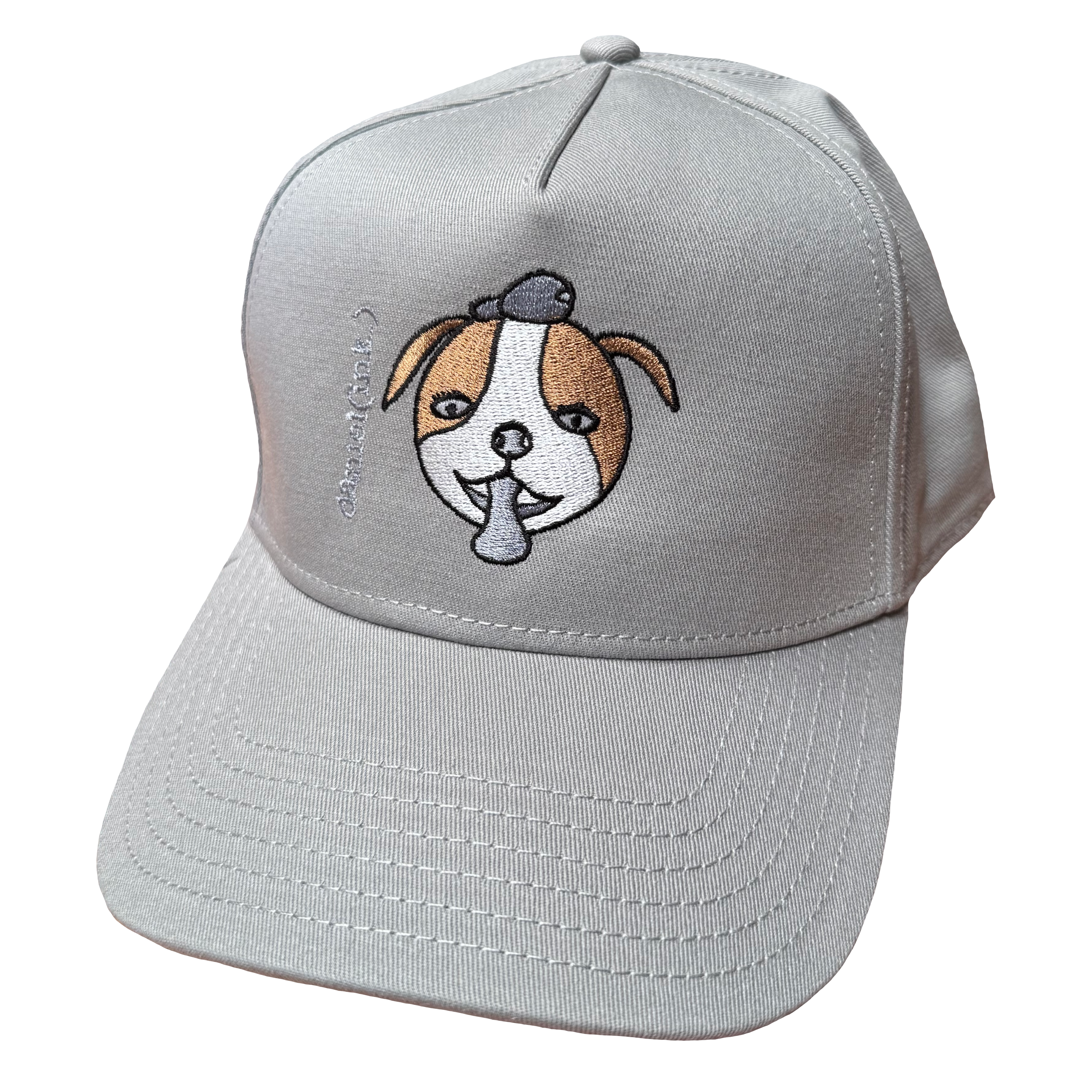 Storm snapback cap featuring an embroidered image of a dog's face in brown and white. The dog has a round head, floppy ears, wide eyes, and its tongue is sticking out. The name daniel(ink.) is embroidered in silver thread next to the dog's face.