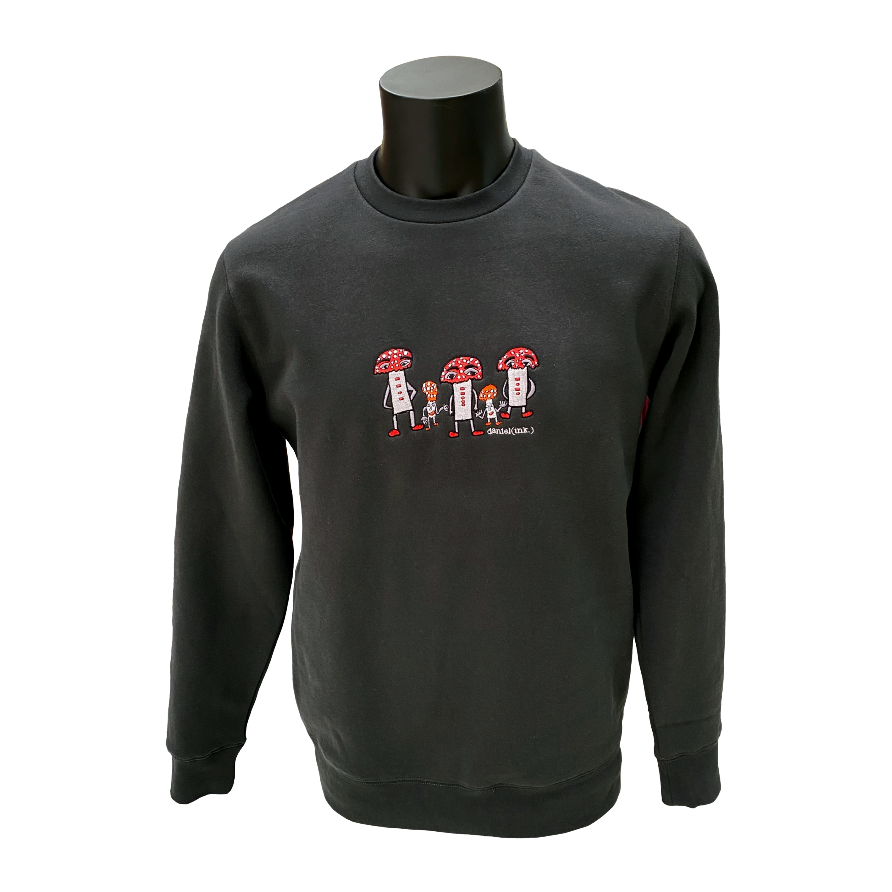 Unisex coal coloured crew jumper featuring an embroidered image of five humanoid mushroom figures, three large and two small, standing next to each other. Each mushroom figure has a red mushroom cap, red shoes, and red accents. The three large mushrooms also have red buttons on their chests which spell "magic" in Morse code. The name daniel(ink.) is embroidered in silver thread underneath the mushroom people.
