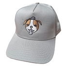 Storm snapback cap featuring an embroidered image of a dog's face in brown and white. The dog has a round head, floppy ears, wide eyes, and its tongue is sticking out. The name daniel(ink.) is embroidered in silver thread next to the dog's face. 