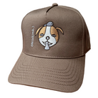 Walnut snapback cap featuring an embroidered image of a dog's face in brown and white. The dog has a round head, floppy ears, wide eyes, and its tongue is sticking out. The name daniel(ink.) is embroidered in silver thread next to the dog's face. 