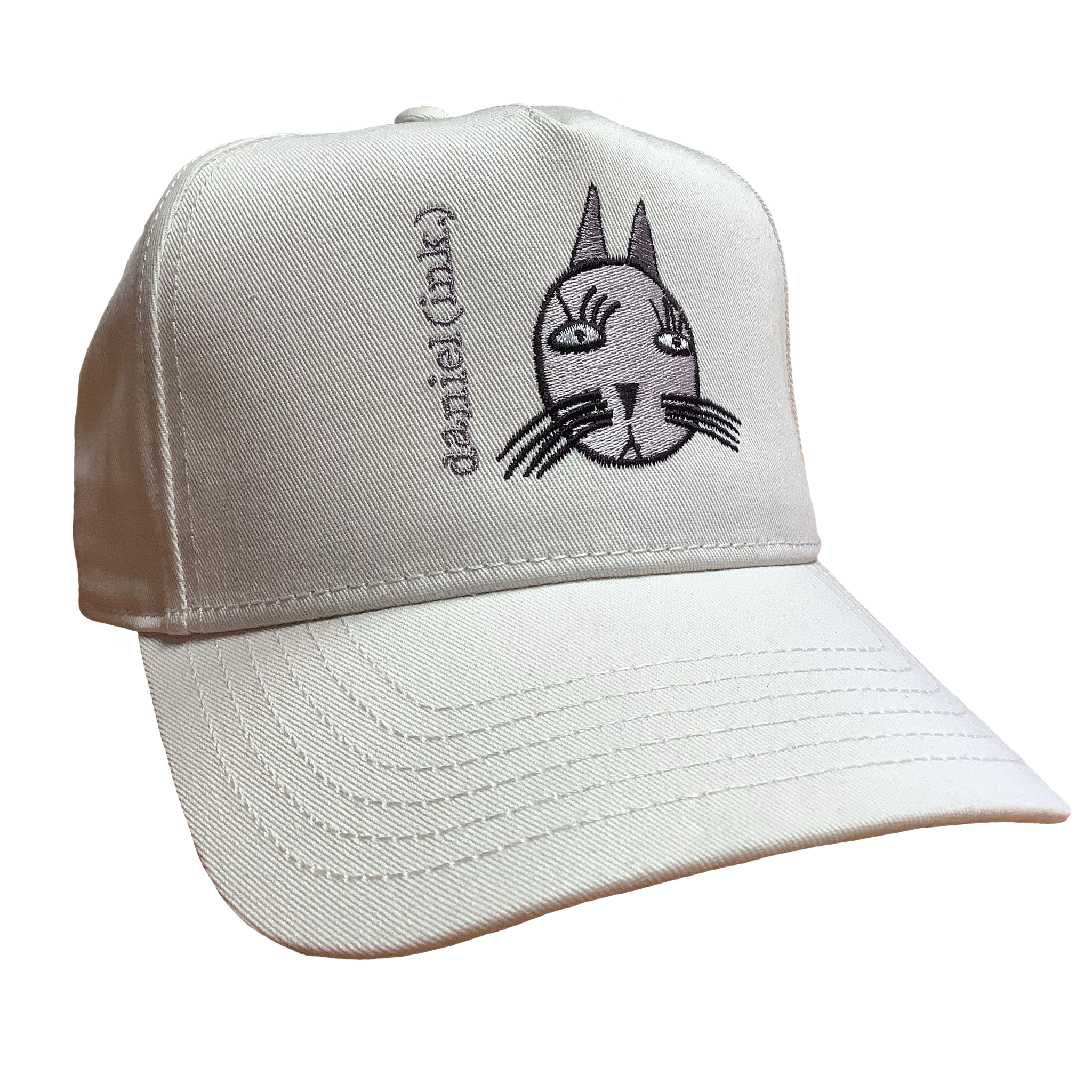 Ecru snapback cap featuring an embroidered image of a cat's head in silver. The cat has long pointy ears, long eyelashes, and long whiskers coloured black. The name daniel(ink.) is embroidered in silver thread next to the cat's head. 
