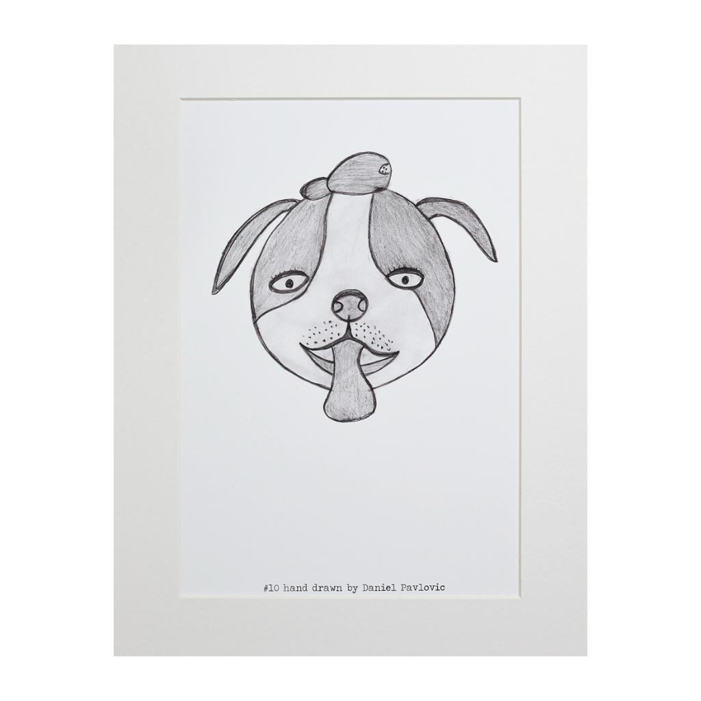 Original print of Design #10 Toby The Dog. The dog has a round head, floppy ears, wide eyes, and its tongue is sticking out. The design is printed on white backing board and displayed in a white frame. 